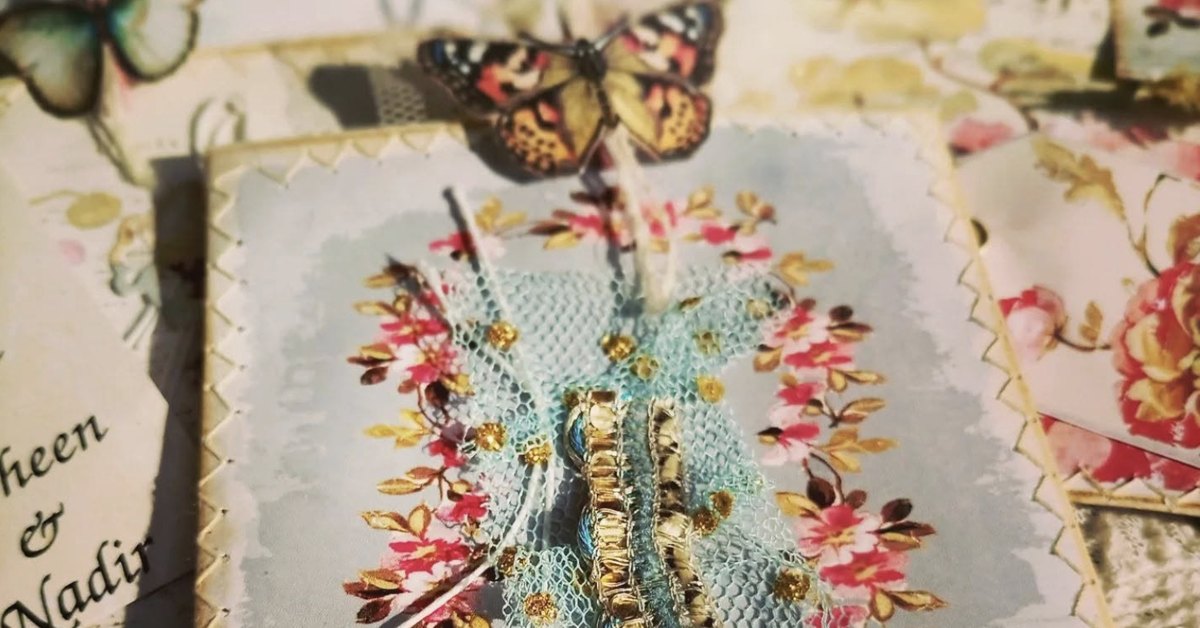 Handmade envelope journal pages with a paper butterfly, tulle, gold trim and a floral wreath