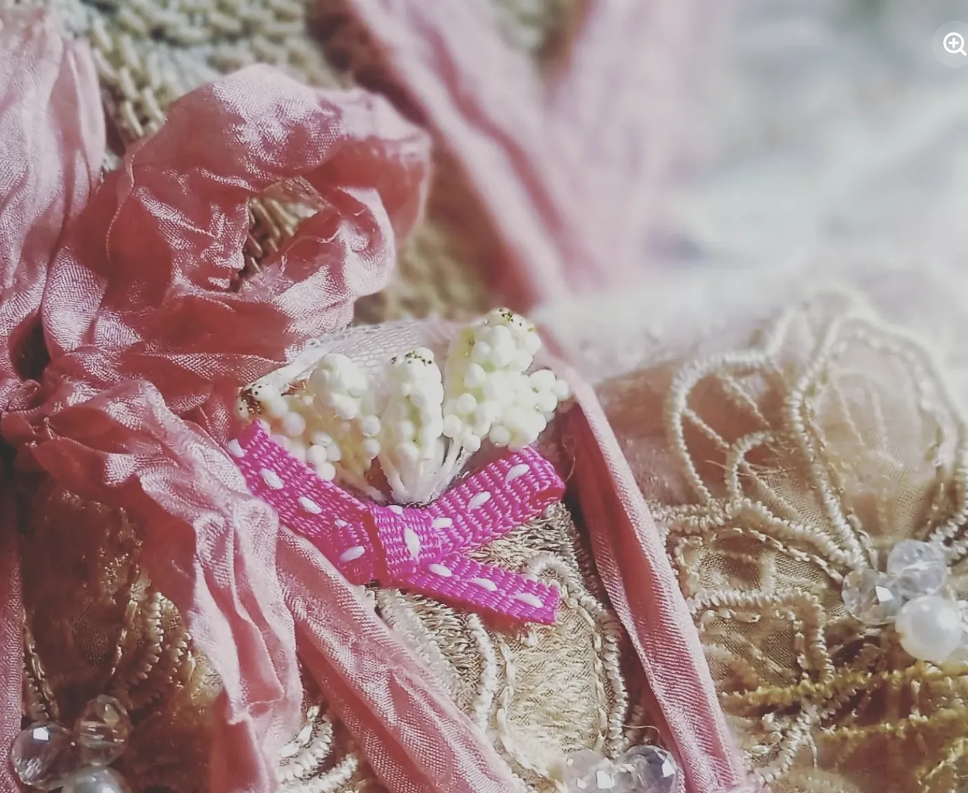 Crushed pink silk ribbon over gold lace