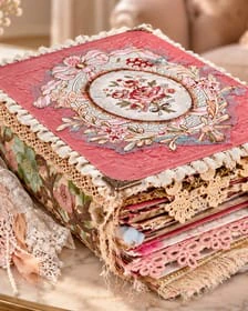 A closed Trinketz journal with a lace and embroidered cover