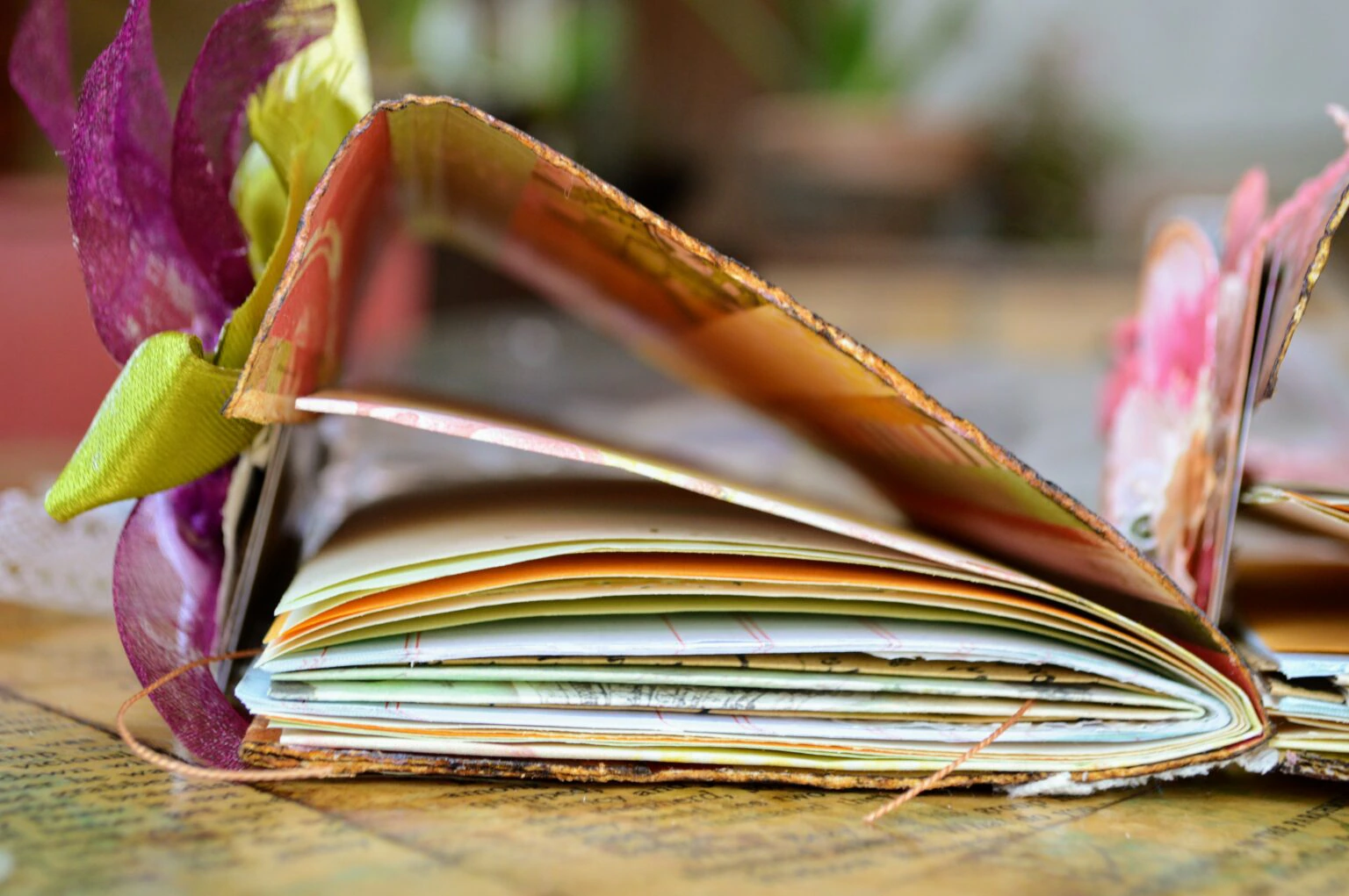 A handmade junk journal with ribbons, fanned pages and layered papers